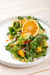 Juicy salad with arugula , orange and avocado. On a light background.