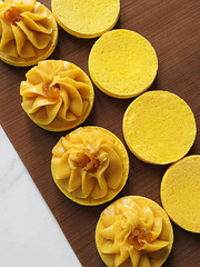 Process of making macarons. filling with mango and passion fruit on yellow macarons