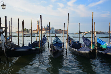 Fototapeta na wymiar Gondolas in lagoon of Venice on sunrise, Italy