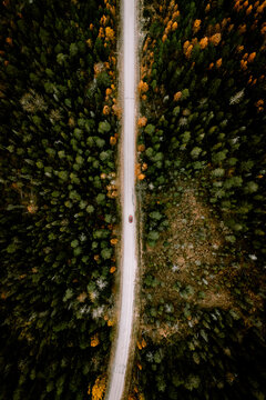 Aerial view of fall road with autumn woods and first snow in Finland.
