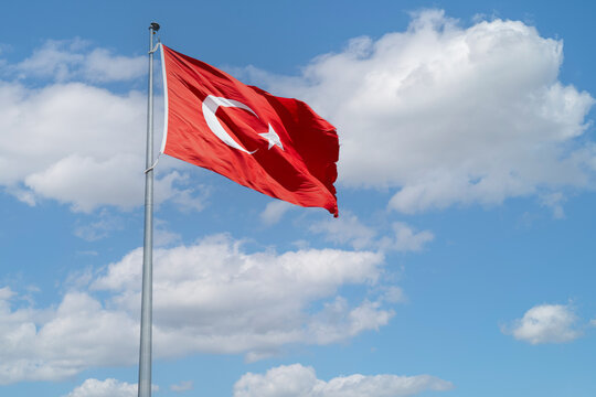 Flag of Turkey on blue sky with clouds background