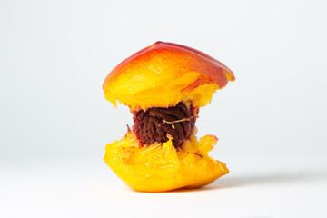 Bitten peach on a white background. Delicious and juicy fruit. peach core