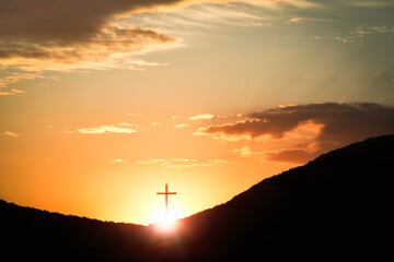 The sunset sky The red sun and clouds and the brightly shining cross of the Holy Church of Jesus...