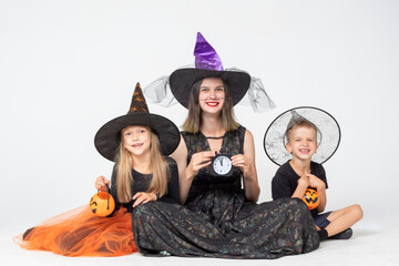A happy family, a mother and children in creepy witch and sorcerer costumes holding black watches...