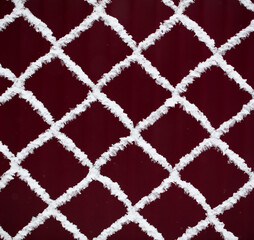 White snowflakes on a metal fence.