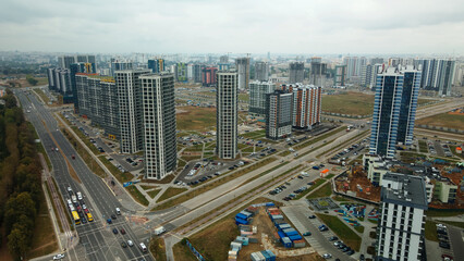 Naklejka na ściany i meble Construction site of a new city block. Construction of multi-storey buildings. Overcast weather. Aerial photography.