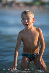 Happy little boy laughing on the shore, happy kid enjoying on the beach resort, summer concept holiday, Emilia Romagna, Italy.