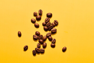 Roasted coffee beans on yellow background