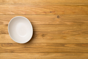Empty round plate on wooden background, top view
