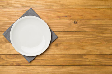 Empty round plate on wooden background, top view