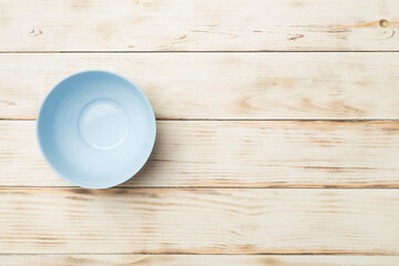 Empty round plate on wooden background, top view