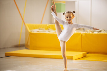 Little girl practising gymnastics at aerobic school