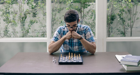 Man developing chess strategy, playing board game.