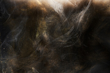 Golden sparkling abstract background, luxury black smoke, acrylic paint underwater explosion, cosmic swirling ink © amixstudio