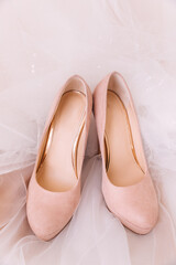 Heeled shoes on white table and dress indoors, close-up
