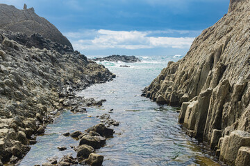 coastal cliffs formed by columnar basalt at low tide