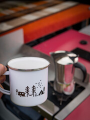 Morning coffee from a moka pot into a tin cup in nature