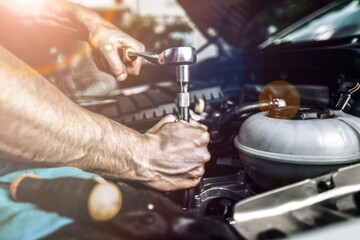 Male mechanic fix a car in the garage