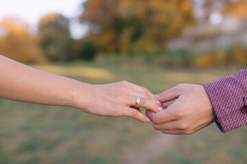 hands of newlyweds holding each other during a walk in nature.