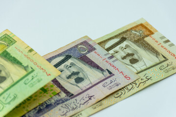 Collection of Saudi Arabia riyal banknotes on a white background. Selective focus.
