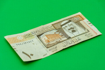 Saudi Arabia riyal banknote on a green background. Selective focus.