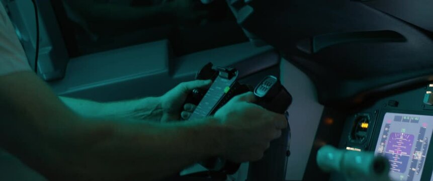 CU Commercial aircraft pilot adjusting flight parameters of the plane during the flight at high altitude. View from inside the cabin. Real aircraft, nighttime shot