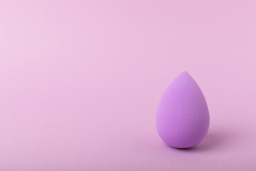 Beauty blender on a lilac background.Sponge for makeup cosmetics. Makeup products. Beauty concept. Place for text. Space for copy. Flat lay