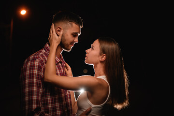side view of attractive young couple hugging and looking at each other