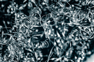 Iron metal shavings, curls, gray metal background. Macro shooting of metal processing, turning...