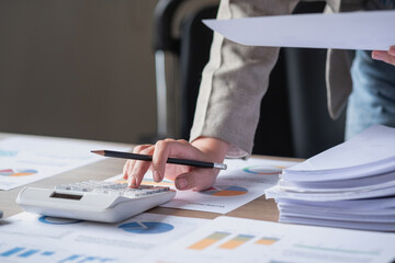 Fototapeta premium marketing, finance, accounting, planning, female accountant using laptop calculator and documents, charts, graphs in the analysis of the company's profit