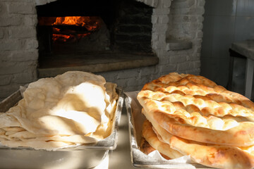 Traditional bread in a Turkish bakery during the Ramadan period - Ramazan pide, in a stone oven, vertical image.