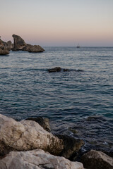 waves on the beach at sunset against the backdrop of mountains. rocks and sea.