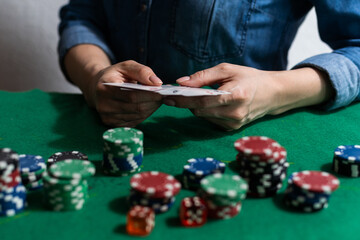 woman hand on green poker table with chips