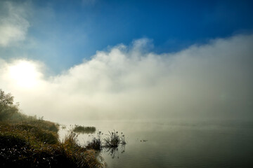 Fog on the river in autumn morning. Idyllic autumn landscape.