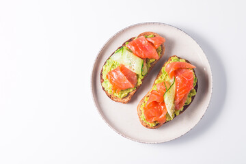 Open sandwich with smoked and salted salmon for healthy breakfast. Trout and avocado on bruschetta toast. 