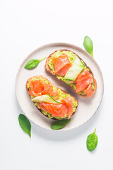 Open sandwich with smoked and salted salmon for healthy breakfast. Trout and avocado on bruschetta toast. 