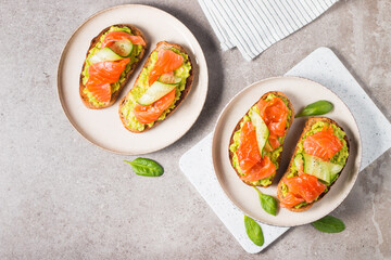 Open sandwich with smoked and salted salmon for healthy breakfast. Trout and avocado on bruschetta toast. 
