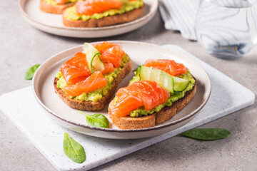 Open sandwich with smoked and salted salmon for healthy breakfast. Trout and avocado on bruschetta toast. 