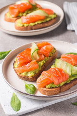 Open sandwich with smoked and salted salmon for healthy breakfast. Trout and avocado on bruschetta toast. 