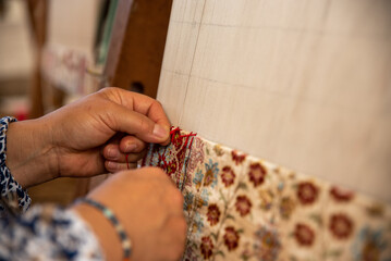 Carpet weaving using traditional techniques on a loom. , close-up of weaving and handmade carpet production.