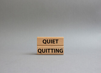 Quiet quitting symbol. Concept word Quiet quitting on wooden blocks. Beautiful grey background....