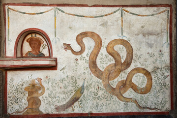 Pompeii ruins. Fresco with snakes in garden. UNESCO World Heritage Site in Campania, Italy. Europe heritage and culture concept.