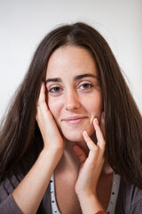 Fototapeta premium Portrait of a young and sweet natural woman without makeup with long brown hair