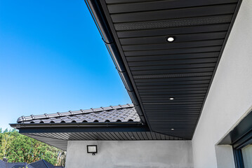 A modern graphite herringbone roof lining is attached to the trusses, visible turned on LED lights. © Michal
