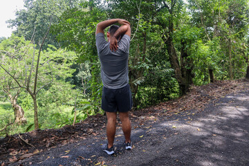 Normal weight young man Stretching his arms to Warm Up for a Workout