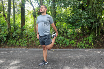 Normal weight young man Stretching his Legs to Warm Up for a Workout