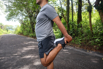 Normal weight man Stretching his Legs to Warm Up for a Workout closeup