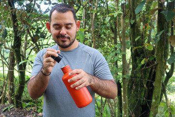Sporty young man opening an orange bottle with a black cap