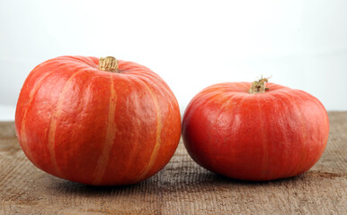 Red kuri squashes on a rough woody texture background. Selective focus.
