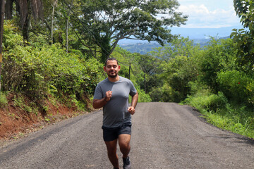 Young mid weight man jogging and smiling front view